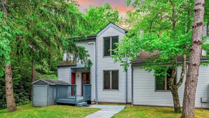 A two-story house with a porch, a small shed, and a well-maintained lawn. - Harmony Ridge by Avantstay Fireplace, Large Deck & Forest Views (Lake Harmony)