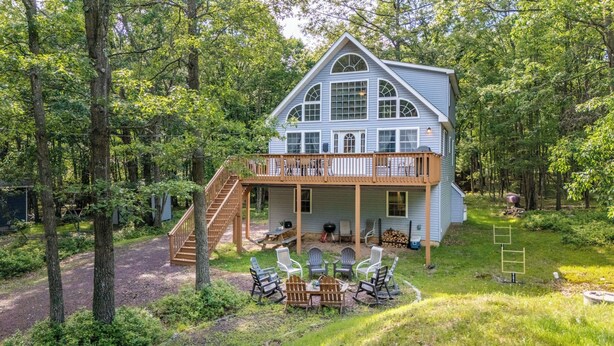 A two-story house with a balcony, surrounded by trees. - The Nest at Brier Crest by Avantstay Game Room, Expansive Deck & Fire Pit (Blakeslee)