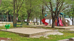 A playground with swings, a slide, and a sandpit. - 7mins to Skiing, Fire Pit, Game Table Lake Access Hygge Home by Avantstay (Blakeslee)
