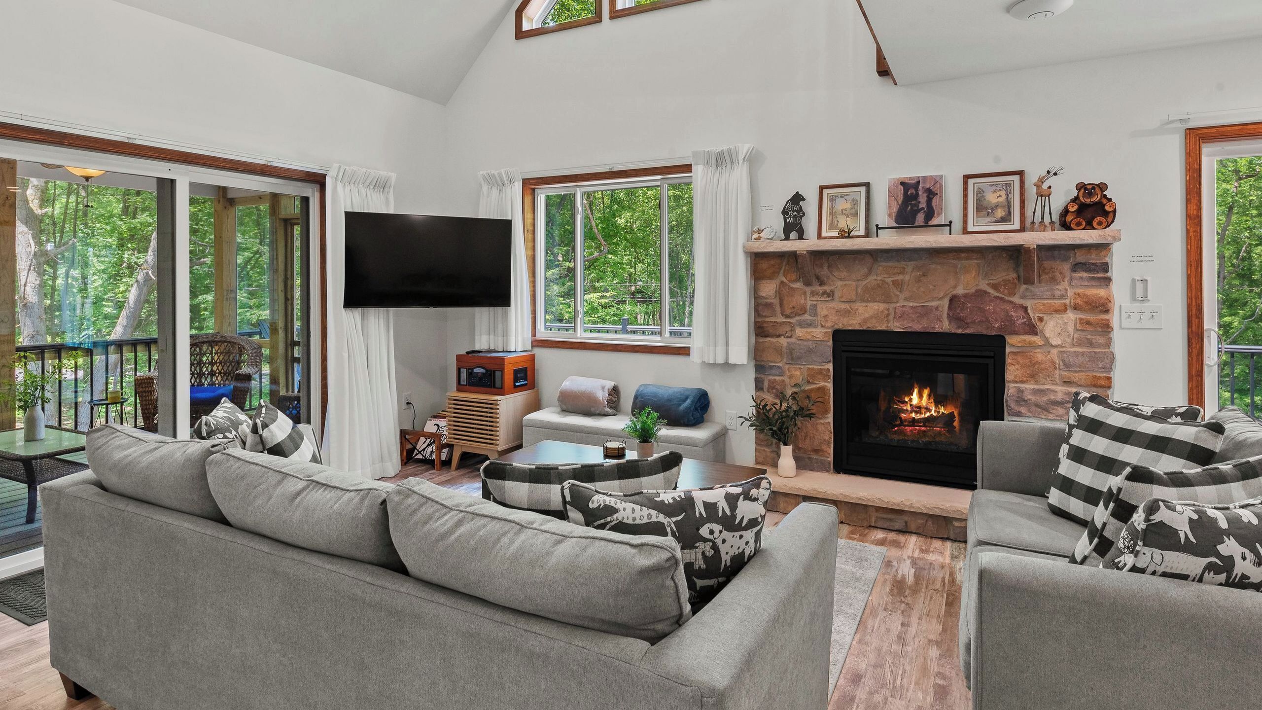 A living room with a fireplace, a television, and a sofa with patterned cushions.