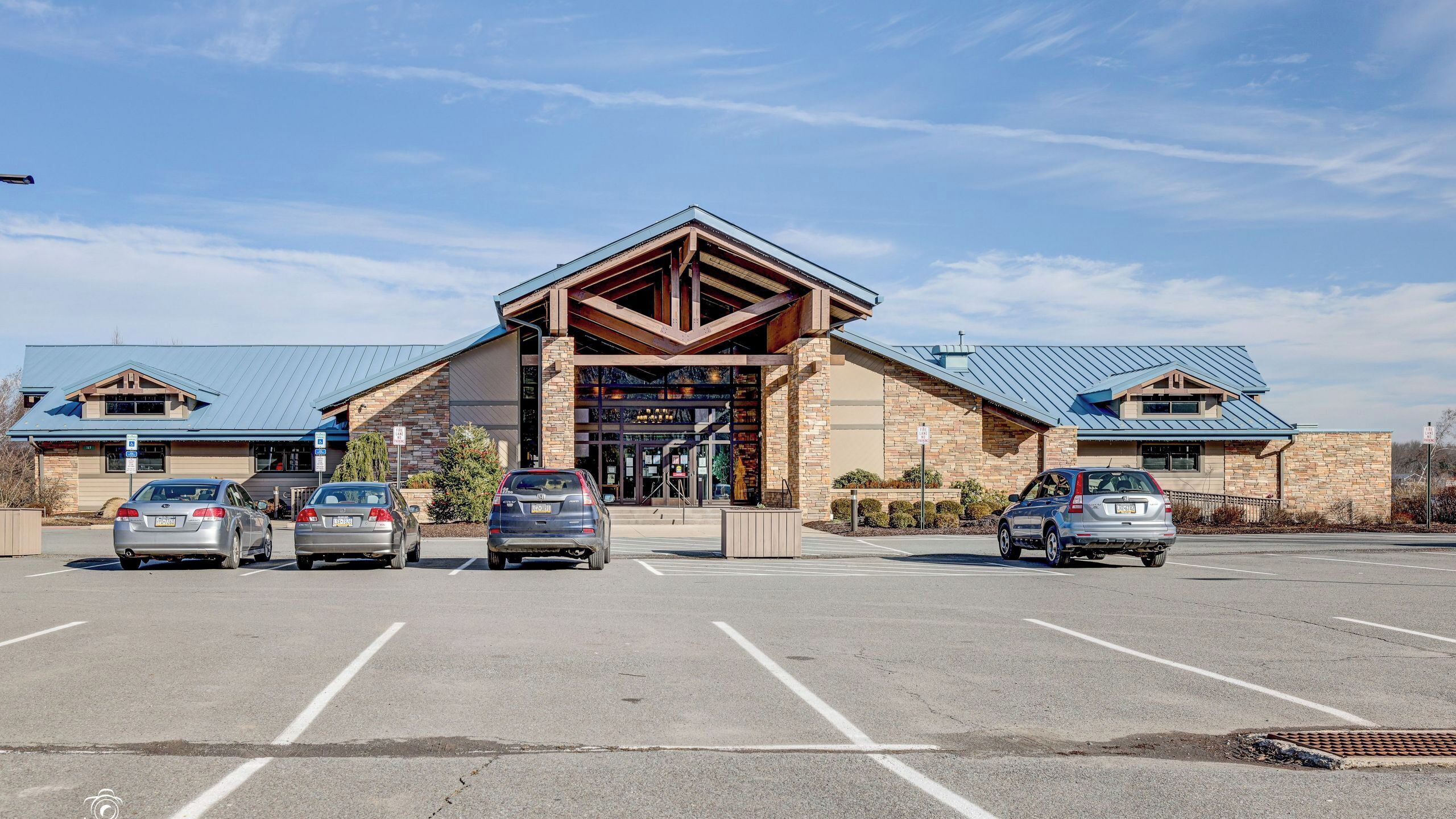 A building with a large parking lot and a covered entrance.