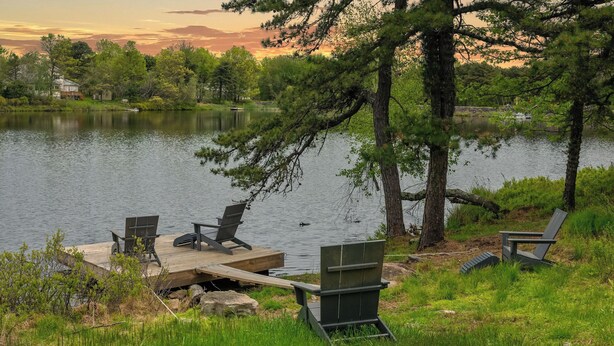 Une terrasse au bord du lac, avec des chaises, et une jetée qui s’avance dans l’eau.