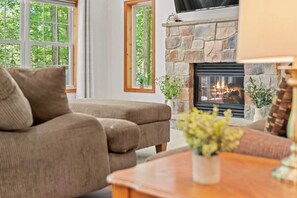 A living room with a stone fireplace, a sofa, and a coffee table.