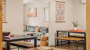 Una sala de estar moderna con un sofá, una mesa de centro y un comedor con una mesa y bancos.