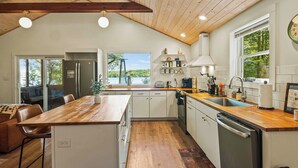 A modern kitchen with wooden countertops, white cabinets, and a large island. - Lake Daze by Avantstay Lakefront w/ Modern Interior, Enclosed Porch & Hot Tub (Pocono Summit)