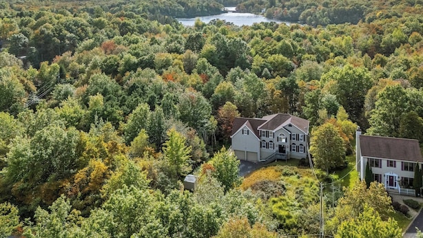 A large house surrounded by dense forest with a lake in the background. - Mountain Mindset by Avantstay Pool, Hot Tub, Game Room, Firepit (Long Pond)