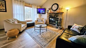 A living room with a sofa, armchair, coffee table, and fireplace. - Summit Serenity by Avantstay Central Location w/ Mountain Views & Deck (Tannersville)