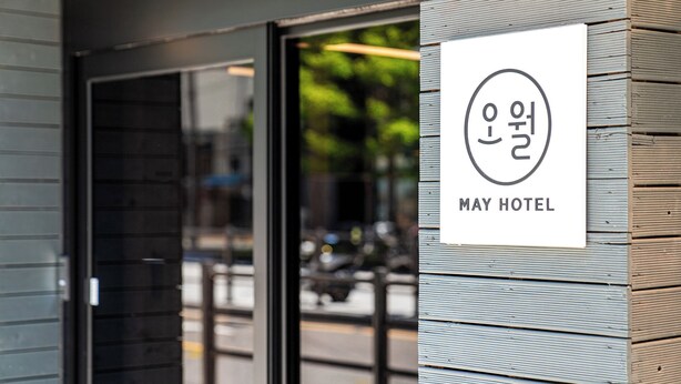 Letrero del Hotel May con un diseño moderno, que incluye logotipo y nombre.