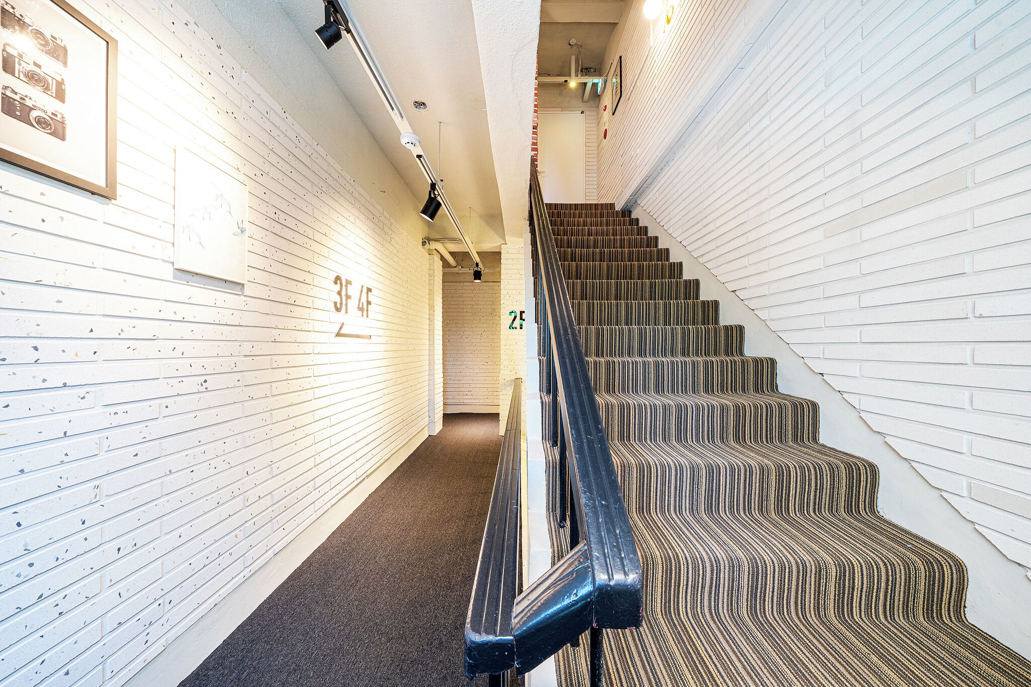A staircase with a striped carpet leading to a landing.