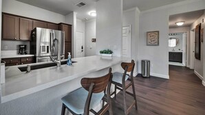 A modern kitchen with a large island, stainless steel appliances, and wooden bar stools. - Shop & Golf! Gem w/ Pool Access in Scottsdale (Scottsdale)