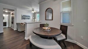 A dining area with a round table, cushioned benches, a ceiling fan, and a window with blinds. - Shop & Golf! Gem w/ Pool Access in Scottsdale (Scottsdale)