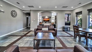 A spacious living area with a brown leather sofa, a wooden coffee table, and a dining table with chairs. - Shop & Golf! Gem w/ Pool Access in Scottsdale (Scottsdale)