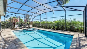 Una piscina techada con vistas a la vegetación tropical.