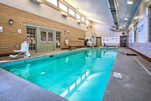 Ein Hallenbad mit klarem Wasser, einem Rettungsschwimmerstuhl und einer Poolleiter.