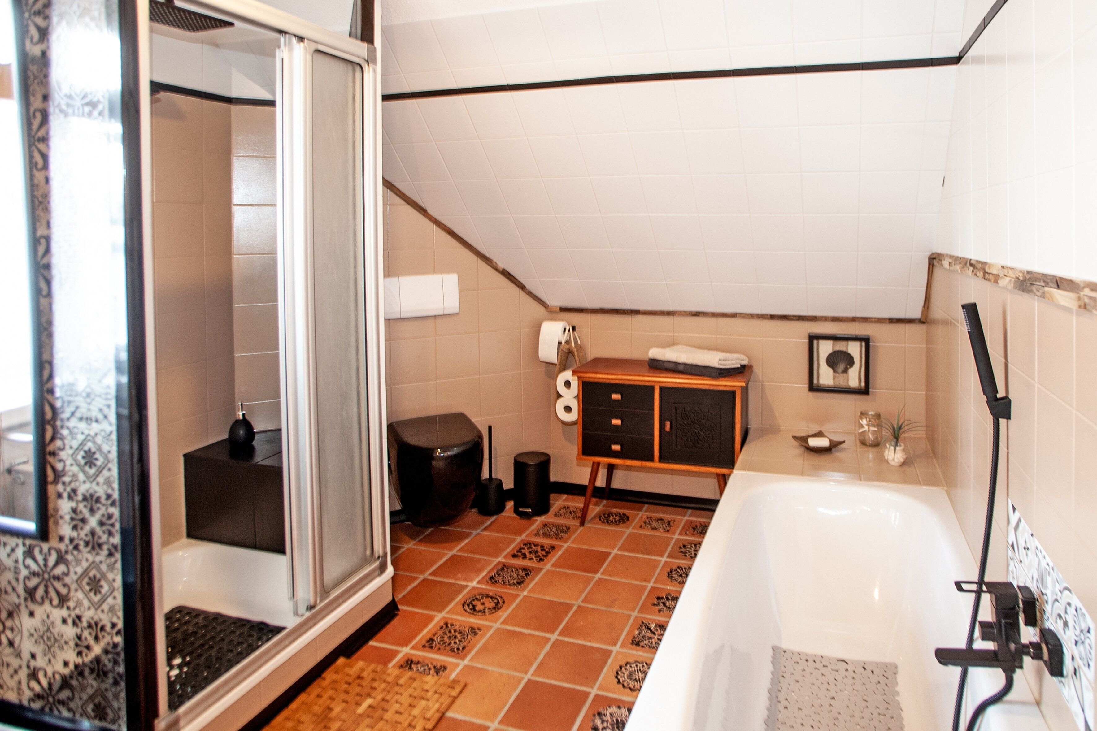 Un baño con ducha, bañera, inodoro, lavabo y un armario.