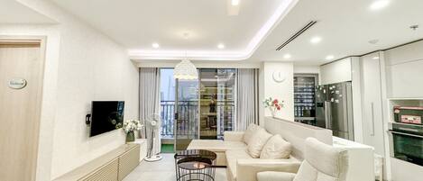 Una sala de estar moderna con sofá, televisor y comedor.
