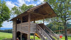 Une cabane en bois avec un escalier et une véranda couverte.