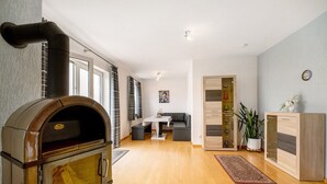 Una sala de estar moderna con chimenea de leña, una mesa de comedor y un rincón de descanso.