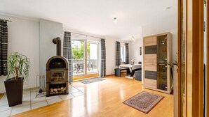 Un espacio habitable amplio con chimenea, una mesa de comedor y un ventanal grande.