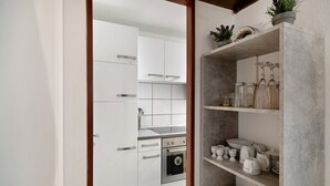 A modern kitchen with white cabinets, stainless steel appliances, and a marble countertop. - Apartment 'Ferienwohnung Alpensicht' with Lake View, Shared Garden and Wi-Fi (Oberteuringen)