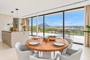 A modern dining area with a view of a mountain and a town.