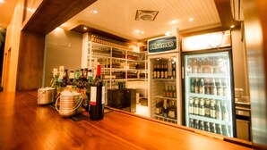 A bar area with a wooden counter, bottles of wine, and a refrigerated display case labeled "Hisense". - Royal Reach Udawalawe (Udawalawa)
