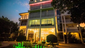 A hotel with a well-lit entrance, a fountain in the courtyard, and a sign that reads "Royal Beach." - Royal Reach Udawalawe (Udawalawa)