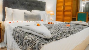 A neatly made bed with a patterned bedspread, a tufted headboard, and a wooden wardrobe in the background. - Royal Reach Udawalawe (Udawalawa)