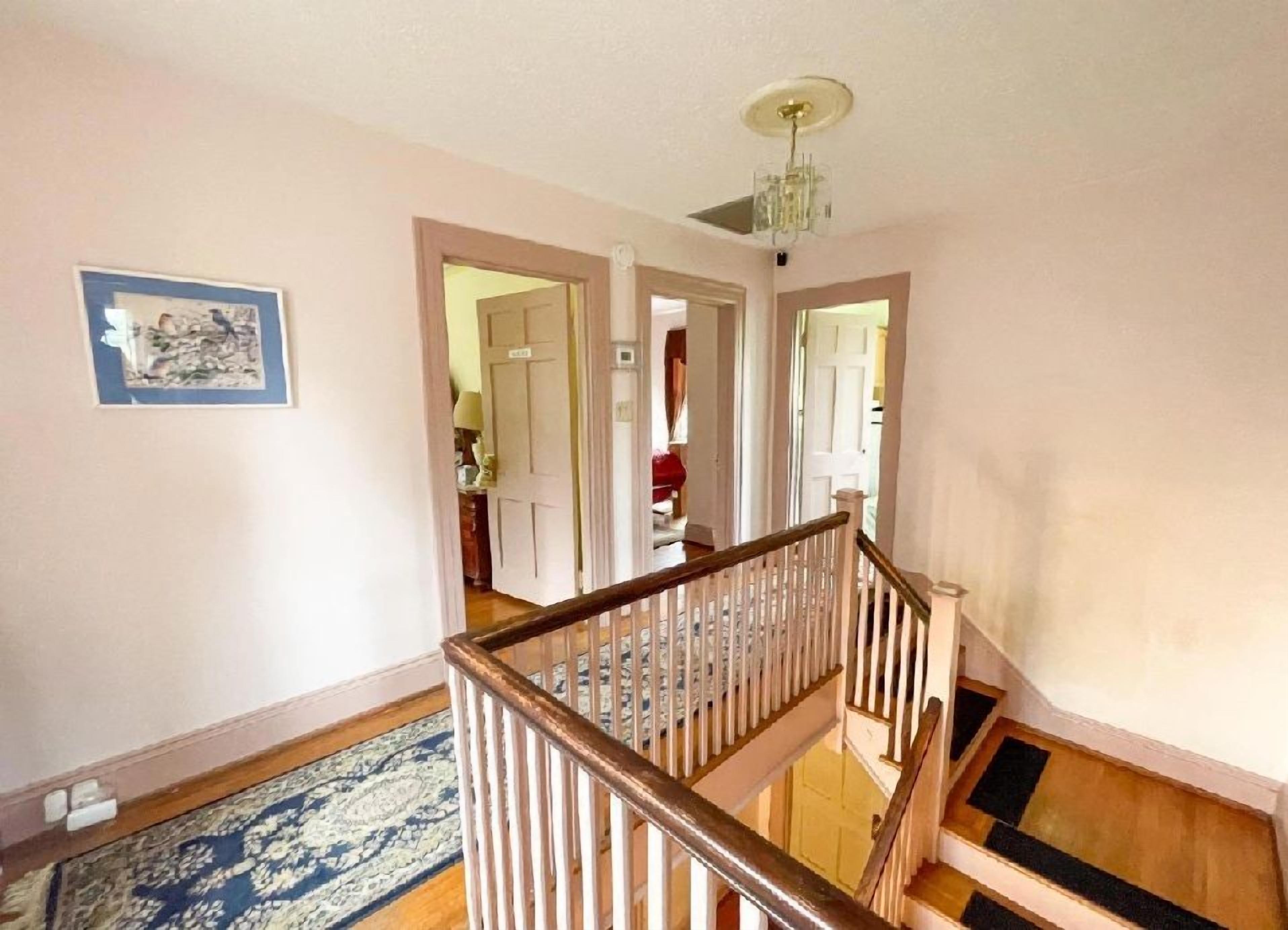 A staircase with a wooden handrail and a patterned carpet.