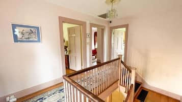 A staircase with a wooden handrail and a patterned carpet.
