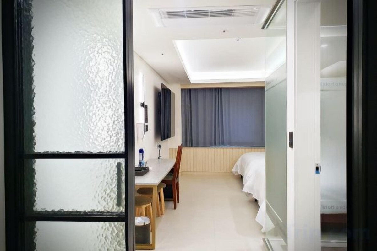 Habitació d'hotel amb un llit, escriptori i cadira.