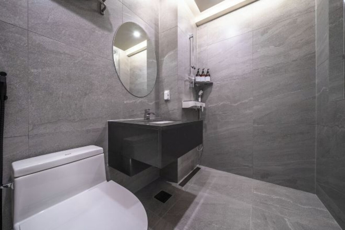 Een moderne badkamer met toilet, wastafel en spiegel.