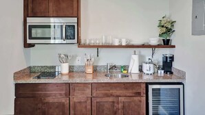 Une cuisine compacte équipée d’un four à micro-ondes, d’une machine à café et d’un réfrigérateur.