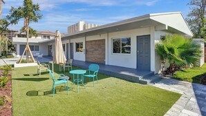 Une maison moderne avec une pelouse bien entretenue, un espace extérieur aménagé pour se détendre et un ciel dégagé.