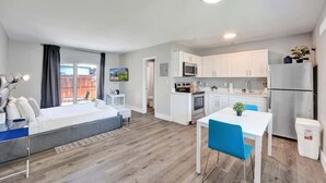 A modern apartment with a living area, kitchenette, and a balcony.
