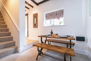 Eine Treppe führt zu einem Essbereich mit einer hölzernen Bank und einem Tisch für zwei Personen.