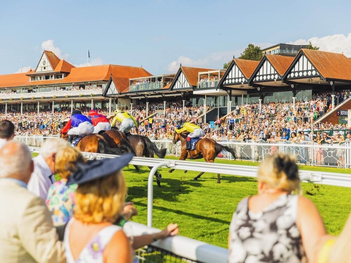 A horse race event with spectators in a stadium.