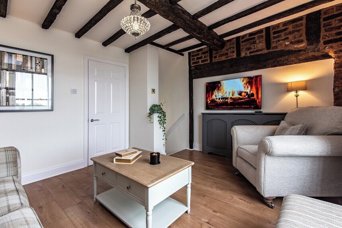 A cozy living room with a fireplace, a television, and a comfortable sofa.
