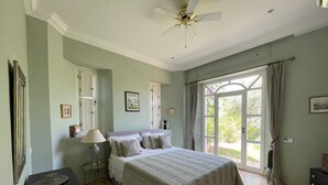 A bedroom with a bed, a ceiling fan, a window with curtains, and a door. -  Relax in the beauty of a saffron farm in the foothills of Atlas Mountains  (Marrakech)