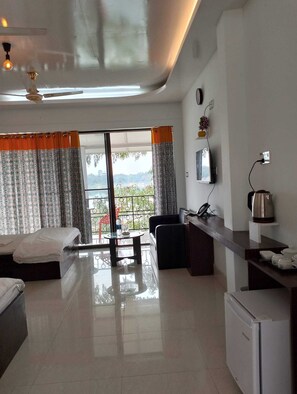 Relax in a spacious room with a large bed, seating area, and wall-mounted TV.