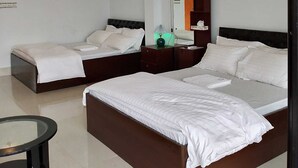 A modern hotel room with two beds, a small table, and a ceiling fan. - Rangadip Resort Rangamati (Rangamati Sadar)