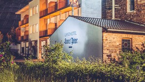 A hotel with a sign reading "Landhotel Sanct Peter" and a modern building with balconies. - Landhotel Sanct Peter (Bad Neuenahr-Ahrweiler)