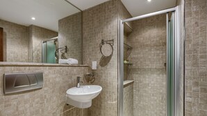 A modern bathroom with a glass-enclosed shower, a white sink, and a towel rack. - Aphrodite Hills Rentals - 1 Bedroom Apartment - AHA12 (paphos)