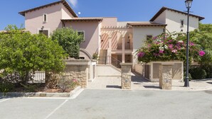 A two-story building with a central staircase, stone pillars, and a paved entrance area. - 2 Bedroom Apartment - AHI02 (paphos)
