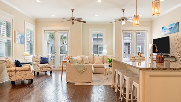A spacious living room with a large sofa, two armchairs, and a dining area with bar stools. - Emerald Gem by AvantStay | Pool Access, 3mins to Beach! (Watersound)