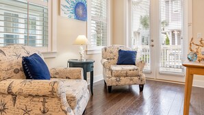 A living room with nautical-themed furniture, a lamp, and a decorative piece on a table. - Emerald Gem by AvantStay | Pool Access, 3mins to Beach! (Watersound)
