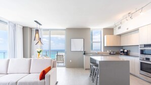 A modern kitchen with a central island, a dining area with a view, and a living room with a sofa and a view. - Bay View|Front Ocean|Amazing Pool (Hollywood)