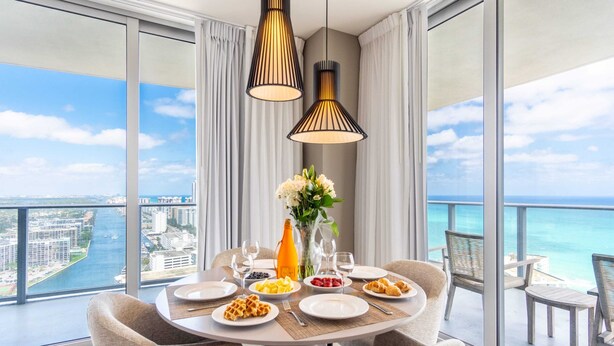 A dining area with a table set for four, overlooking a cityscape and the sea. - Bay View|Front Ocean|Amazing Pool (Hollywood)