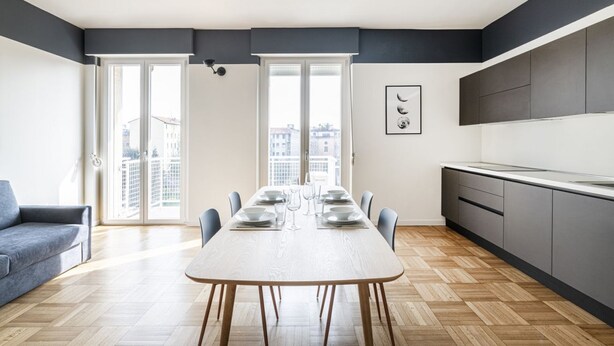 Un appartement moderne comprenant un coin repas, une cuisine et un canapé.