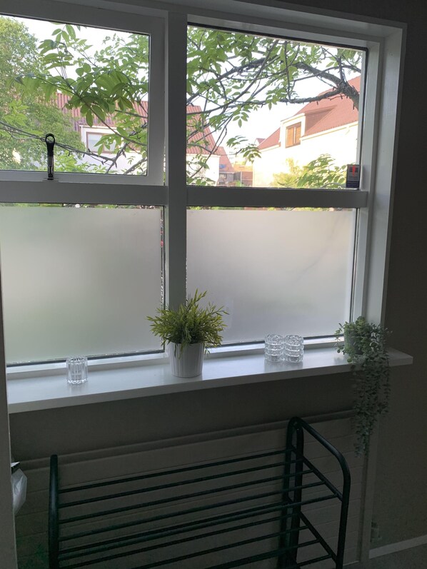 A window with frosted glass, a potted plant, and a glass candle holder on a shelf. - Great 8 Person House, Reykjavik, Free use of Car! (Reykjavik)
